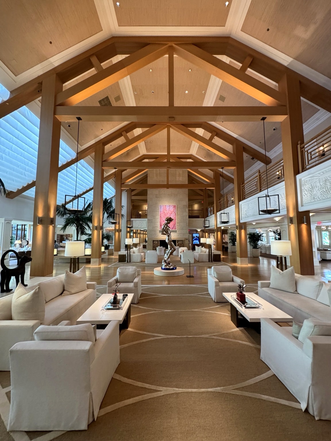 Four Seasons Resort Lanai grand lobby — soaring wooden beam cathedral ceiling with bronze sculpture
